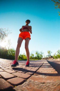 Parkta sabah dürtmek. Kız sokak şehir çalışır. Şafakta eğitim. Bir kadın kaldırımda yürüyor.