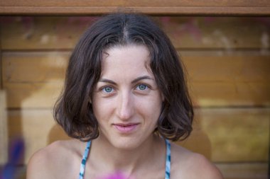 Bir kadın portresi. Esmer gülümseyen. Bir yüz makyaj olmadan. Yorgun kız.