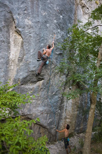 攀岩的自然地形 男人在大自然中训练 朋友们从事体育运动 一个男人保险一个合伙人 极限运动的安全性 — 图库照片