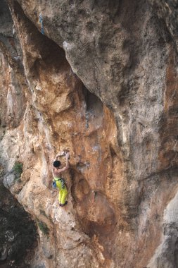 Bir adam kaya tırmanıyor. Doğada tırmanma. Fitness açık havada. Aktif yaşam tarzı. Ekstrem Sporlar. Doğal bir rahatlama atlet trenlerde.