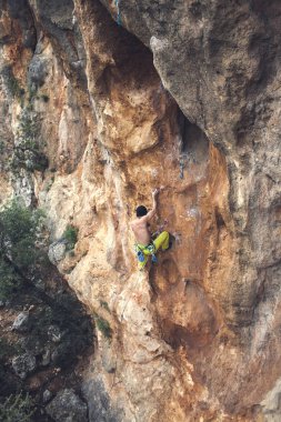 Bir adam kaya tırmanıyor. Doğada tırmanma. Fitness açık havada. Aktif yaşam tarzı. Ekstrem Sporlar. Doğal bir rahatlama atlet trenlerde. Türkiye'de dağcılık.