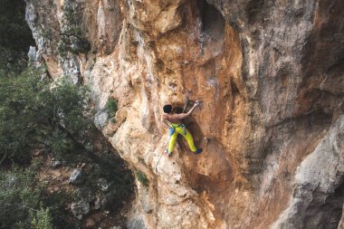 Bir adam kaya tırmanıyor. Doğada tırmanma. Fitness açık havada. Aktif yaşam tarzı. Ekstrem Sporlar. Doğal bir rahatlama atlet trenlerde.