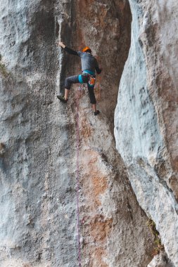 Kasklı bir adam kayaya tırmanıyor. Doğaya tırmanmak. Spor salonu açık havada. Aktif yaşam tarzı. Ekstrem sporlar. Sporcu doğal bir rahatlama ile antrenman yapar. Türkiye 'de kaya tırmanışı.