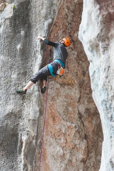 一个戴头盔的男人爬上岩石 在自然界中攀爬 室外健身 积极的生活方式 极限运动运动员靠一种自然的救济进行训练 在风景如画的地方接受训练 在土耳其攀爬 — 图库照片