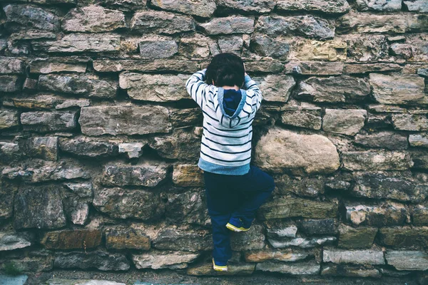 Ragazzo Arrampica Sulla Recinzione Pietra Bambino Sta Cercando Scalare Muro — Foto Stock