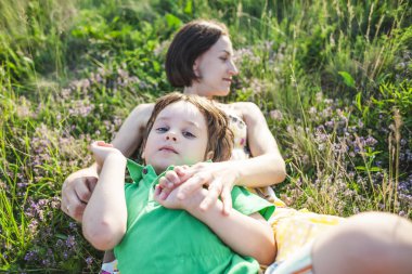 Oğlan ve annesi çayırda yalan söylüyorsun. Bir kadın ve oğlu batan güneşin alanına yürüyor. Çocuk ile anne doğa üzerinde zaman harcıyor.