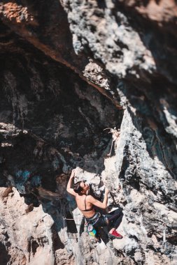 Bir kadın rock tırmanıyor. Doğada tırmanma. Fitness açık havada. Aktif yaşam tarzı. Ekstrem Sporlar. Doğal bir rahatlama atlet trenlerde. Türkiye'de dağcılık.
