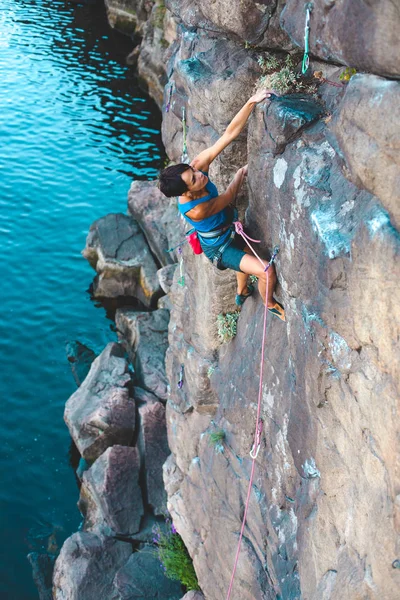 水上的登山者 一个女人爬上岩石 自然地形的训练 极限运动 海滨登山路线 — 图库照片