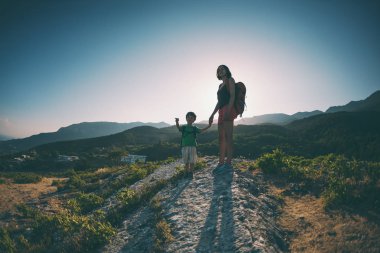 dağlarda bir çocukla seyahat. çocuk annesi gitmek istediği yere gösterir.
