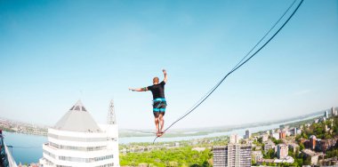 İki bina arasında uzanan bir çizgi boyunca bir adam girer. Bir adam denge irtifada yakalar. Highline şehri.