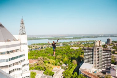 İki bina arasında uzanan bir çizgi boyunca bir adam girer. Bir adam denge irtifada yakalar. Highline şehri.