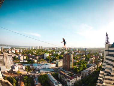 İki bina arasında uzanan bir çizgi boyunca bir adam girer. Aşırı eğlence. Yükseklik korkusu. Adam şehrin üzerinde Dengeleme.