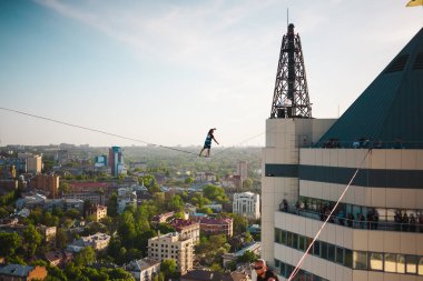 İki bina arasında uzanan bir çizgi boyunca bir adam girer. Aşırı eğlence. Yükseklik korkusu. Adam şehrin üzerinde Dengeleme.