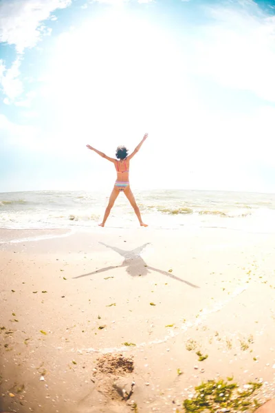 Een meisje is springen op het strand. — Stockfoto