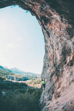 Bir adam kaya tırmanıyor. Doğada tırmanma. Fitness açık havada. Aktif yaşam tarzı. Ekstrem Sporlar. Doğal bir rahatlama atlet trenlerde. Eğitim pitoresk bir yerde. Türkiye'de dağcılık.