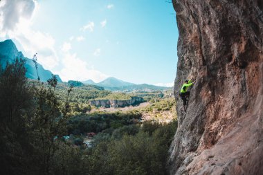 Bir adam kaya tırmanıyor. Doğada tırmanma. Fitness açık havada. Aktif yaşam tarzı. Ekstrem Sporlar. Doğal bir rahatlama atlet trenlerde. Eğitim pitoresk bir yerde. Türkiye'de dağcılık.