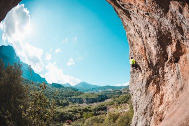 Bir adam bir dağ manzarasına karşı kayaya tırmanır. Sporcu doğal bir rahatlama ile antrenman yapar. Türkiye 'de tırmanış. Kemer şeklinde bir kaya. Mağara. Dağcı zor bir yolun üstesinden gelir..