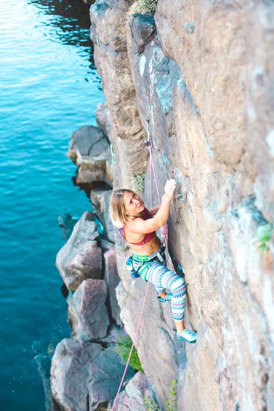 水の上のクライマー 女性は 岩を登っていきます 自然の地形でのトレーニング 極端なスポーツ 海岸沿いに登山ルート — ストック写真