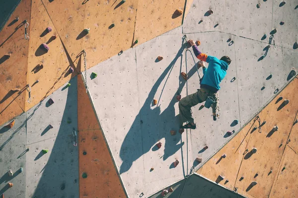 一个登山者在人工救灾 一个人爬上爬墙 在一条街头攀岩墙上训练 比赛准备 — 图库照片