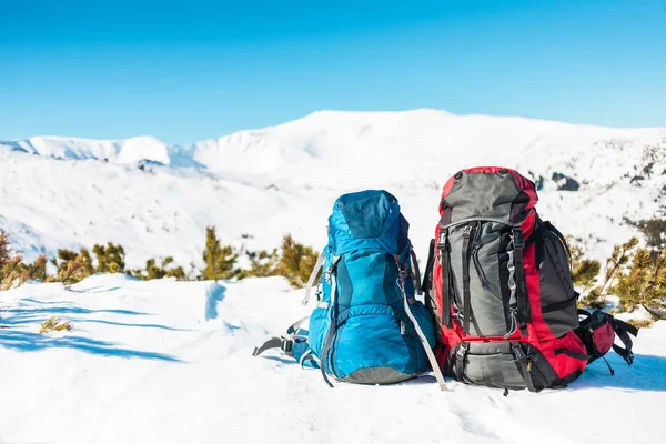 两个背包在 Snow Capped 山和蓝天的背景下 在雪地上的背包 积极的生活方式 冬季徒步旅行 — 图库照片