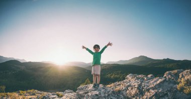 Gün batımında dağın zirvesine çocuğa. Çocuk zirveye tırmandı. Aktif tatiller. Çocuklarla seyahat. Onun elini tuttum çocuk.