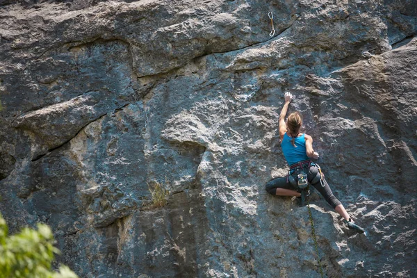 女孩爬上岩石 登山者正在训练攀登岩石 强壮的运动员克服了艰难的攀登路线 极端的爱好 一个女人在大自然中参加体育运动 自然岩石地形 — 图库照片