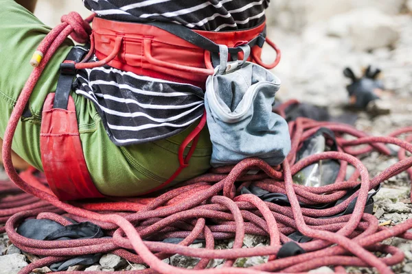 クライマーはロープに座っています 女の子は 結び目をノット 登山ルートを克服するために準備します 女性はエクササイズ後休んでいます 安全システムとマグネシアのバッグをクローズ アップ — ストック写真