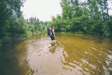Bir adam bir çocukla nehir geçiyor. Baba oğul bir sırt çantası içinde taşır. Sel gelen kurtarma. Asya'da sel mağduru boşaltılmasında. Ormanın içinden bir çocukla seyahat. Aşırı Turizm.