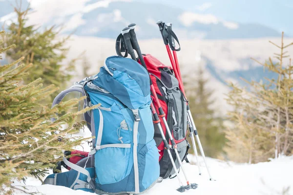 雪をかぶった山々 と青い空を背景に つのバックパック 雪の上のバックパック アクティブなライフ スタイル 冬のトレッキング ハイキングのための機器 トレッキング スティック — ストック写真