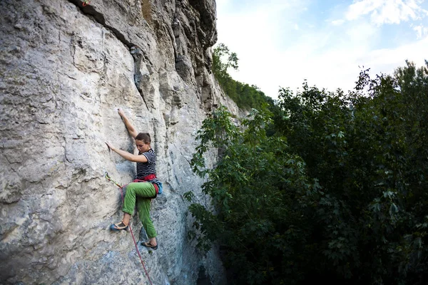 女人克服了艰难的攀登路线 体育女孩爬上岩石 力量和耐力训练 运动员爬上自然的浮雕 — 图库照片
