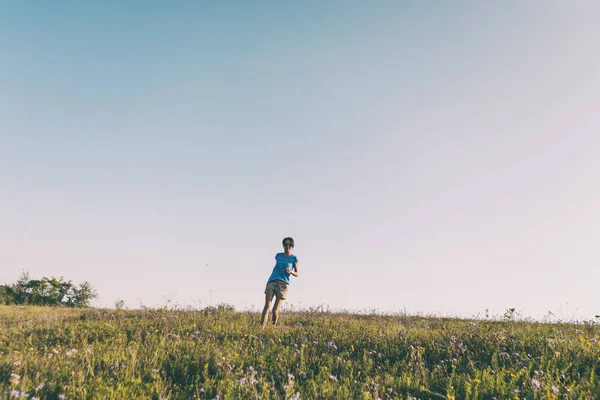 一个女人在日落的田野里散步 女孩在草地上奔跑 — 图库照片
