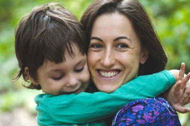 Annemin kucaklama. Çocuk annesi sarılıyor. Doğada oğluyla gülümseyen kadın yürüyor. Bir çocuk olan bir kadın portresi. Aile ile harcanan zamanın yüzdesi.