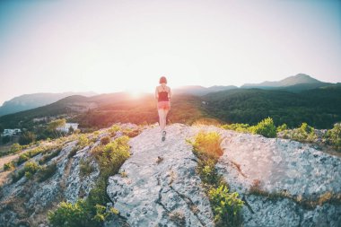 gün batımına karşı Dağları aşarak kızı çalışır. doğada bir sporcu eğitim.
