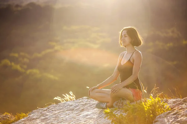 Μια Κοπέλα Κάθεται Στην Κορυφή Ενός Βουνού Στο Ηλιοβασίλεμα Μια — Φωτογραφία Αρχείου