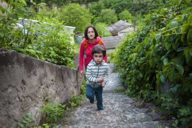Bir çocuk ve annesi eski şehirde yürüyor. Bir kadın oğlunu tarihi yerler ile hareket eder. Çocuk eski kaldırım taşları yürüyor. Ukrayna turistik yerler.
