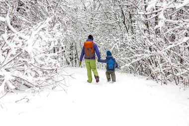 Çocuk annesiyle bir kar kaplı orman yolu üzerinde yürür. Kış tatili. Bir sırt çantası olan bir çocuğun annesi ile eğleniyor.