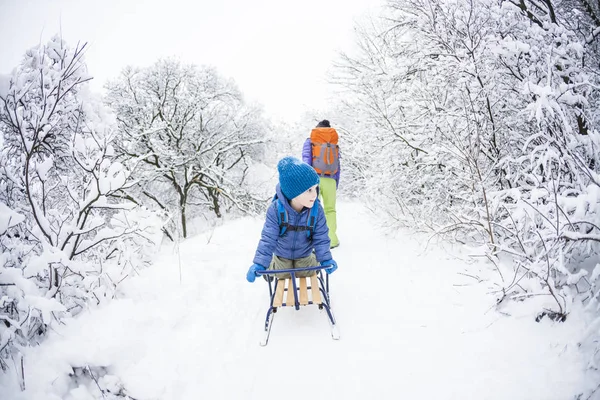 Een Vrouw Het Dragen Van Een Kind Een Slee Moeder — Stockfoto