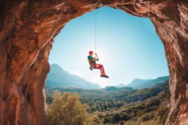 Tırmanıcı bir ipte asılı duruyor. Kızı aşağı gider. Türkiye'de dağcılık. Dağ manzarası. Bir kadın doğa sporları devreye girer. Rock bir kemer şeklinde. Mağaradaki tırmanma rotası.