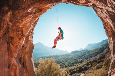 Tırmanıcı bir ipte asılı duruyor. Kızı aşağı gider. Türkiye'de dağcılık. Dağ manzarası. Bir kadın doğa sporları devreye girer. Rock bir kemer şeklinde. Mağaradaki tırmanma rotası.
