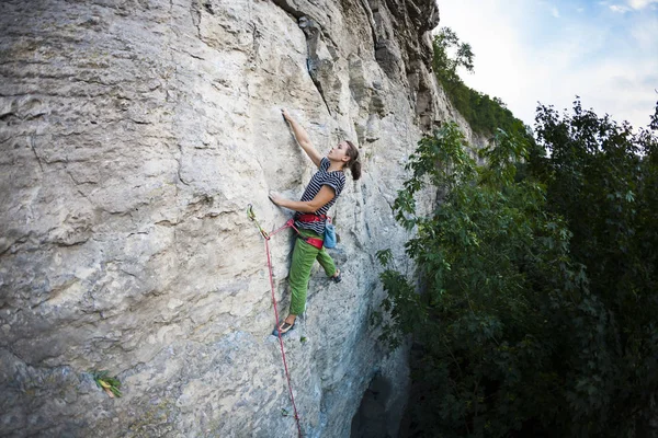 強い女の子は 岩を登っていきます ロック クライミングのトレーニング 登山者は 岩を登っていきます 自然の中を行使します 極端な趣味 高所恐怖症を克服します 強度と持久力のトレーニング — ストック写真