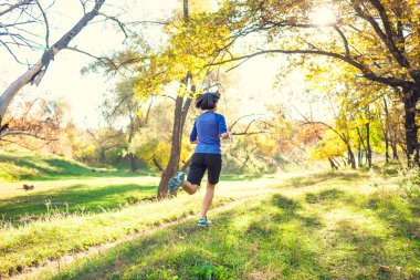 Kız sonbahar Parkı ile çalışır. Doğada ince kadın trenler. Ormanda spor. Esmer bir toprak yol boyunca çalışır.