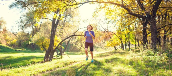 这个女孩穿过秋季公园 苗条的女人在大自然中训练 在森林里运动 褐发女郎沿着泥土小路跑 在崎岖地形上的亚军列车 — 图库照片