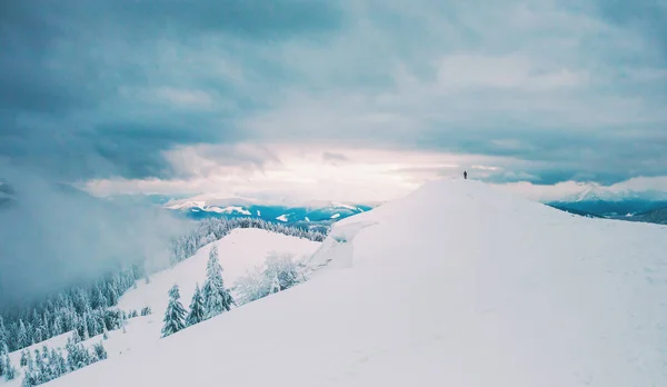 山の中の距離で人のシルエット 冬の風景 雪に覆われた山々 山の上に孤独な男 夜明けの会 — ストック写真