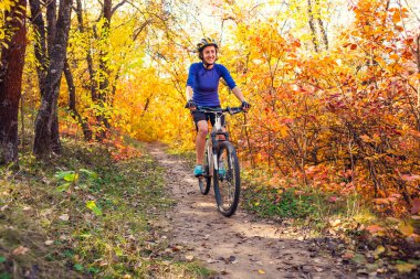 Ormanda bisiklet. Kız bir orman iz üzerinde bisiklet sürmek. Kadın parkta bisiklet sürme. Bisiklet touring. Doğal yerlere seyahat. Sonbahar ağaçlar.