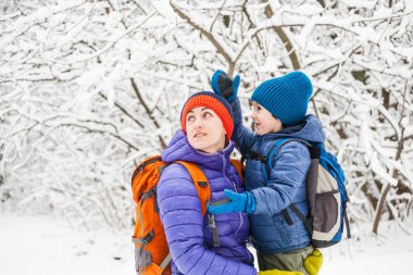 Çocuk anne sarılmak. Bir çocuk annesi bir kış yürüyüş ile. Bir çocuk annesini öper. Kadın oğlunu destekler. Annelik. Aile birlikte vakit geçiriyor. Aile değerleri.