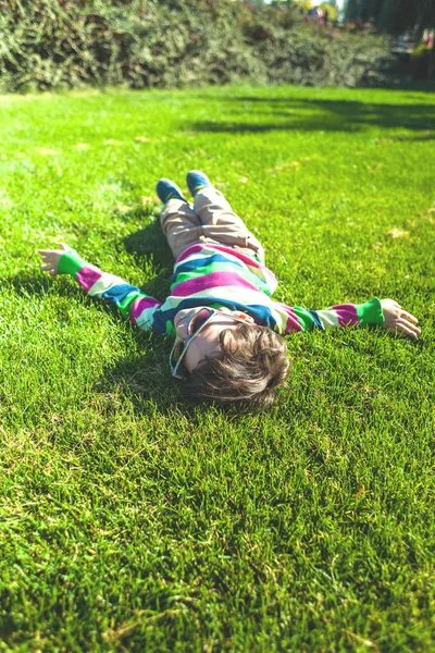 Chico Está Tirado Hierba Niño Está Descansando Una Vista Superior —  Fotos de Stock