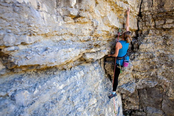 若い女性は岩 自然にアクティブな残りの部分に登山します — ストック写真