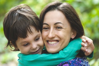 Annemin kucaklama. Çocuk annesi sarılıyor. Doğada oğluyla gülümseyen kadın yürüyor. Bir çocuk olan bir kadın portresi. Aile ile harcanan zamanın yüzdesi.