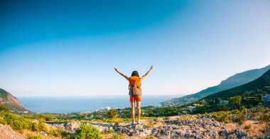 Dağın zirvesine kıza ellerini kaldırdı. Sırt çantası kadınla zirveye tırmandı da onun başarıların keyfini sürdüler. Batan güneşin ışınları. Esmer yükselen güneş ağırlıyor.