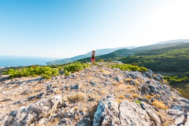 Bir kız dağlarda çalışıyor. Doğa sporları için bir kadın giriyor. İnce esmer bir dağın tepesinde. Skyrunning.